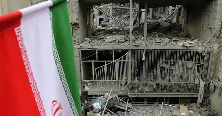 ধ্বংস হওয়া ভবনের সামনে ইরানি পতাকা